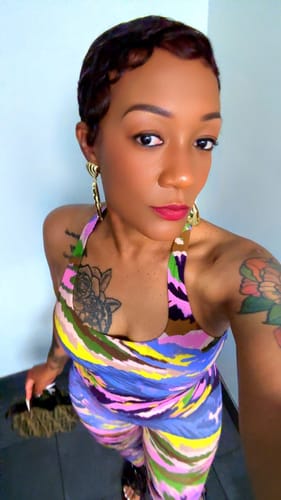 Reviewer wearing the colorful Naked Print Racerback Bodysuit with matching bottoms.