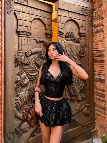 Reviewer posing in the black Onyx Fairydust Sequin Matching Set against an ornate wooden door.