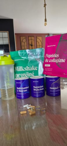 Photo d'un client montrant le pot de Multivitamines et des gélules sur une table avec d'autres produits de la marque.