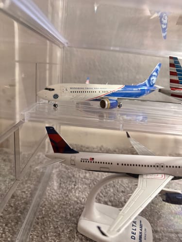 A customer's Alaska 737MAX8 Veterans model plane in a clear display case, with another model plane visible below.