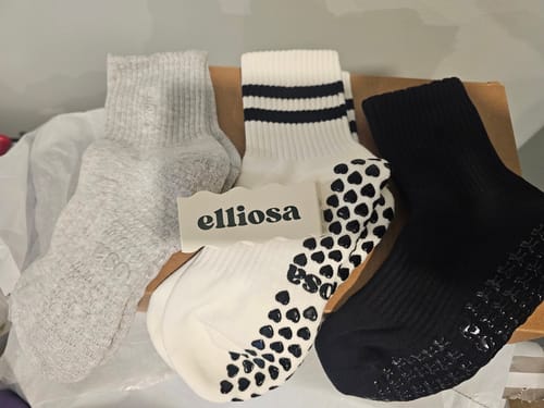 Customer's three pairs of grippy socks in assorted grey, white, and black colors.