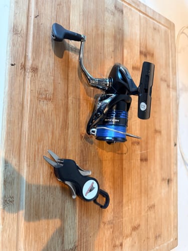 Customer's Waterloo Rod Company Boomerang Long Snip shown on a wooden surface next to a fishing reel.