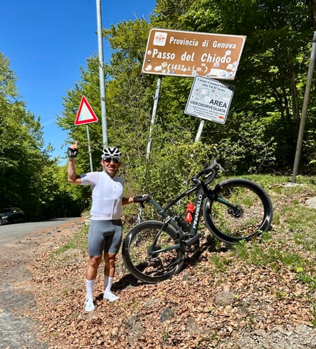 Reviewer wearing the white LIFTTINT 1.X JERSEY, posing with a bicycle on a sunny roadside.