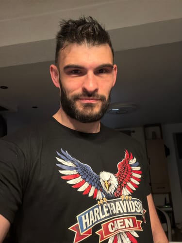 Un client portant le T-Shirt Aigle HDC noir avec un grand motif d'aigle aux ailes tricolores.