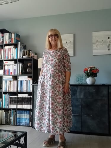 Cliente portant la Robe Louisa roseraie sauvage dans son salon.