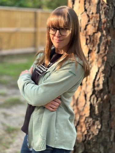 Reviewer standing outdoors in the 80Eighty® Women's Sage ZipHoodie, showing its relaxed fit over a t-shirt.