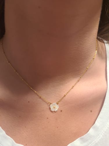 Reviewer wearing the White Blossom Flower Necklace, showing the small flower pendant and delicate gold chain.