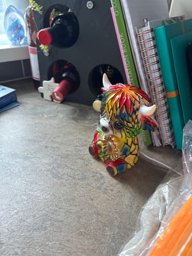 Reviewer's small, colorful Highland Cow lamp sitting on a home countertop.