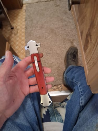 Customer holding the large Gargantuan Godfather OTF Stiletto with its natural wood handle.