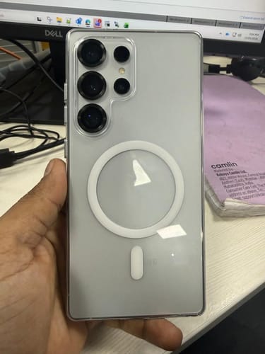 Customer holds their phone in a clear case, with the screen protected by the UltraShield Tempered Glass.