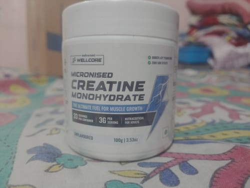 Customer's white tub of Wellcore Micronised Creatine Monohydrate on a patterned surface.