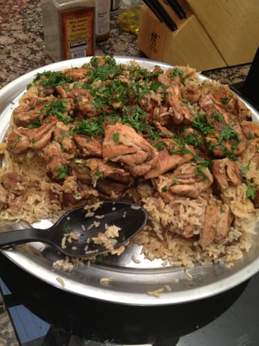 Customer's prepared dish using Halal Chicken Leg & Thigh, served over rice on a large platter and garnished with herbs.