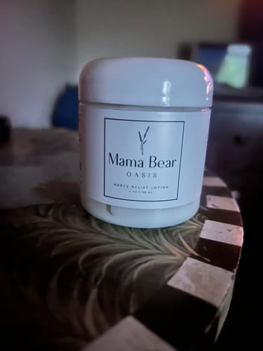 Customer's jar of Mama Bear Nerve Relief Lotion sitting on a patterned nightstand.