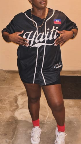 Customer wearing the front of the black Haiti Heritage Custom Baseball Jersey, showing the white 'Haiti' script.