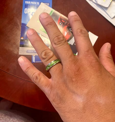 Customer wearing the Viridian ring on their hand, showcasing the vibrant green crystal inlay.