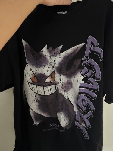 Cliente mostrando la camiseta negra Seed 001 con un estampado grande y desgastado de Gengar.