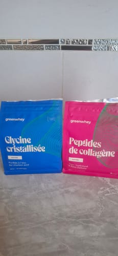 Client montrant le sachet bleu de Glycine cristallisée à côté d'un sachet rose de peptides de collagène.