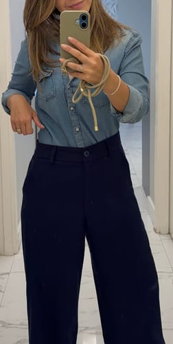 Cliente mostrando sua Case na cor Areia e alça combinando em uma selfie no espelho.