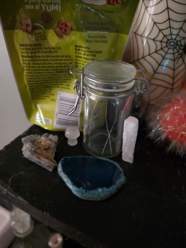 Reviewer's crystals from the monthly club, including a blue agate slice, displayed on a shrine.