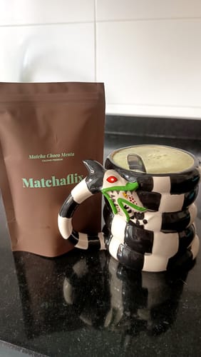 Cliente muestra su paquete de Té Matcha Premium Choco-Menta junto a una taza con la bebida verde preparada.