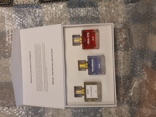 Customer's open OUD Supreme BUNDLE box, displaying three colorful perfume bottles nestled inside.