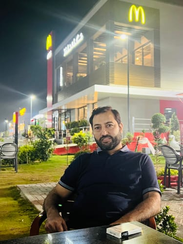 A reviewer sitting at an outdoor table at night with the box for the OUD Supreme BUNDLE in front of them.