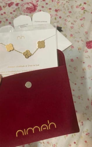 Customer's Sabr, Shukr, Tawakkul Bracelet with intricate charms, shown with its elegant red pouch.