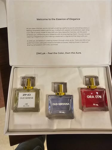 Reviewer's open box of the OUD Supreme BUNDLE, displaying the Oud Serene, Oud Nirvana, and Ora 1776 perfume bottles.