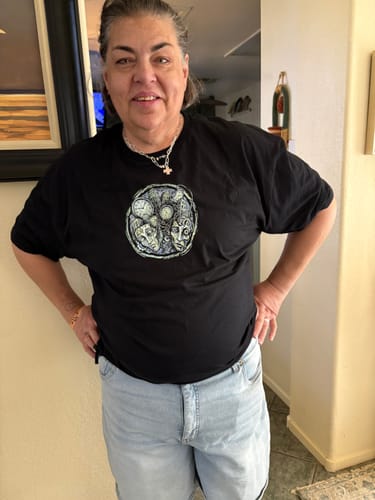 Customer posing indoors while wearing the black Mad World t-shirt.