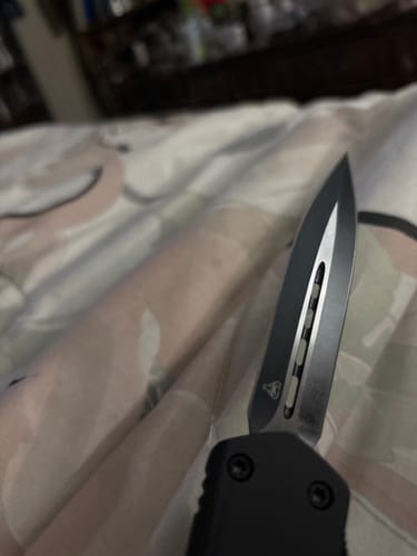 Close-up of a customer's VIPER TEC GHOST OTF knife, showing the sharp, two-tone blade partially extended.