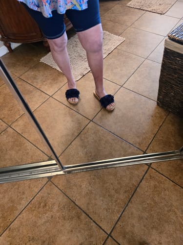 Customer wearing the navy Corky's Wild Child Sandals with textured floral straps indoors on a tile floor.