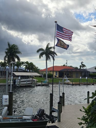 Customer's heavy duty American flag flying on a flagpole over a waterway.