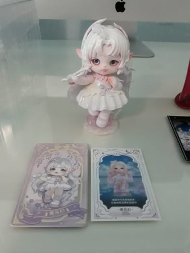 Customer's Flora Journey to the West figure, the white Qingniaohuan character, displayed on a desk with its collectible cards.