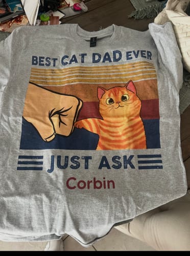 Reviewer's gray personalized shirt for a cat dad, featuring a fist bump graphic and the name 'Corbin'.