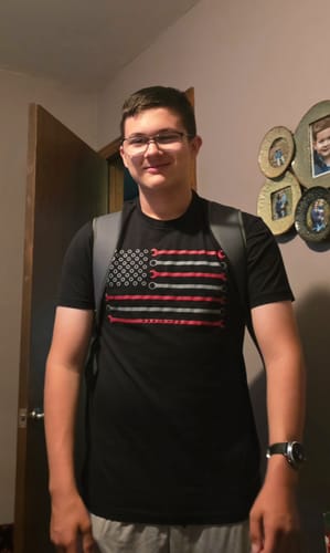 Customer wearing the black 80Eighty Wrench Flag Shirt while standing indoors.
