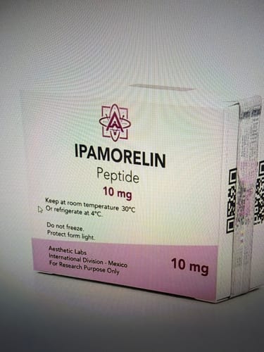Reseñador muestra el empaque blanco y rosa de Ipamorelin de Aesthetic Labs.