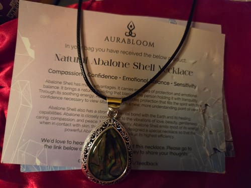 Reviewer's Abalone Shell Necklace from their VIP Crystal Club subscription, lying on its descriptive card.