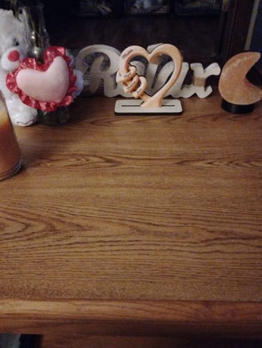 Customer's personalized wooden heart plaque displayed on a wooden dresser among other decor.