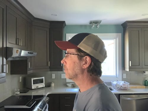 Customer's side view showing the fit and profile of the Big Unstructured Trucker Hat in a kitchen.