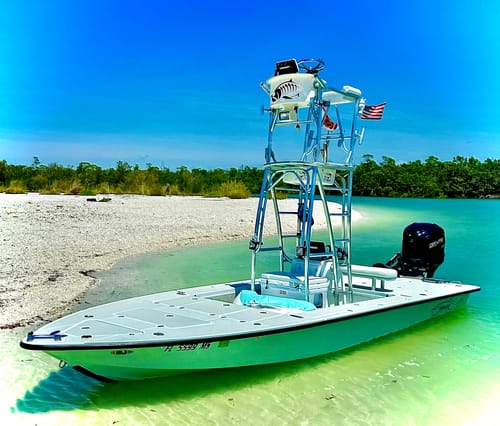 Customer's American Flag flying from a fishing boat beached on a sunny, sandy shore.