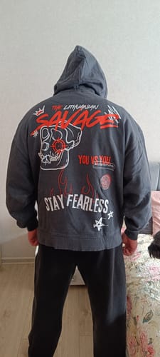 Reviewer from behind wearing the dark grey LITHUANIAN SAVAGE X KNOCK HOODIE, showing the large graphic design on the back.
