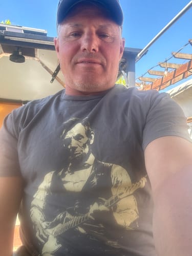 Reviewer taking a selfie outdoors while wearing the grey Lincoln Guitar T-Shirt.