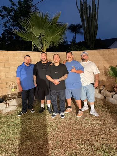 Customers wearing the black Psalm 23:4 Oversized T-Shirt with friends in a backyard setting.