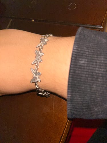 Close-up of a reviewer wearing the adjustable Butterfly Bracelet on their wrist.