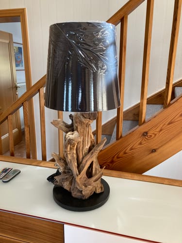 Kundenfoto der Wurzelholz Tischlampe mit rustikalem Fuß. Der schwarze Lampenschirm ist noch in Folie verpackt.