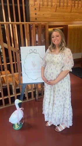 Reviewer smiling while wearing the floral Crinkled Chiffon Dress at her baby shower.
