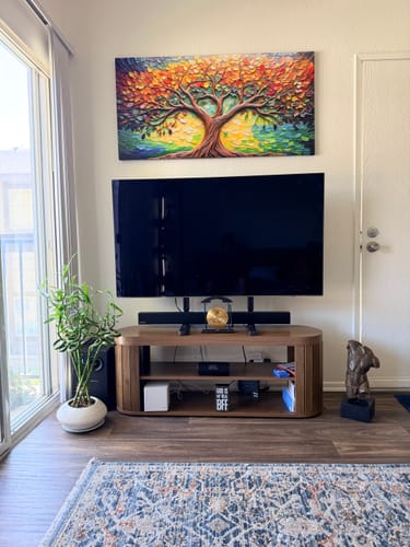 Customer's colorful Tree Of Life Wall Art hanging in a living room above a TV.