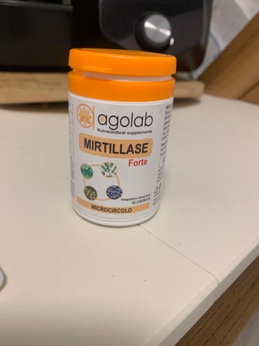 Recensore mostra il flacone di Mirtillase Forte su un ripiano della cucina.
