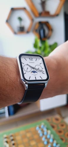 Cliente mostrando su elegante reloj Casio Moonphase en la muñeca, con esfera blanca y correa negra.