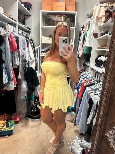 Reviewer takes a mirror selfie in a closet wearing the yellow Citrine Tube Mini Dress, showing its fit and length.
